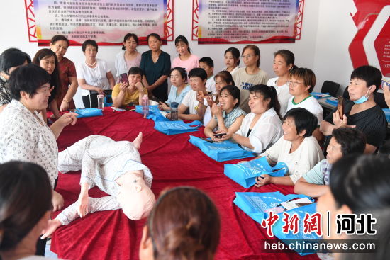 家政老师用假人道具演示帮助老人翻身动作要领。 崔贤飞 摄